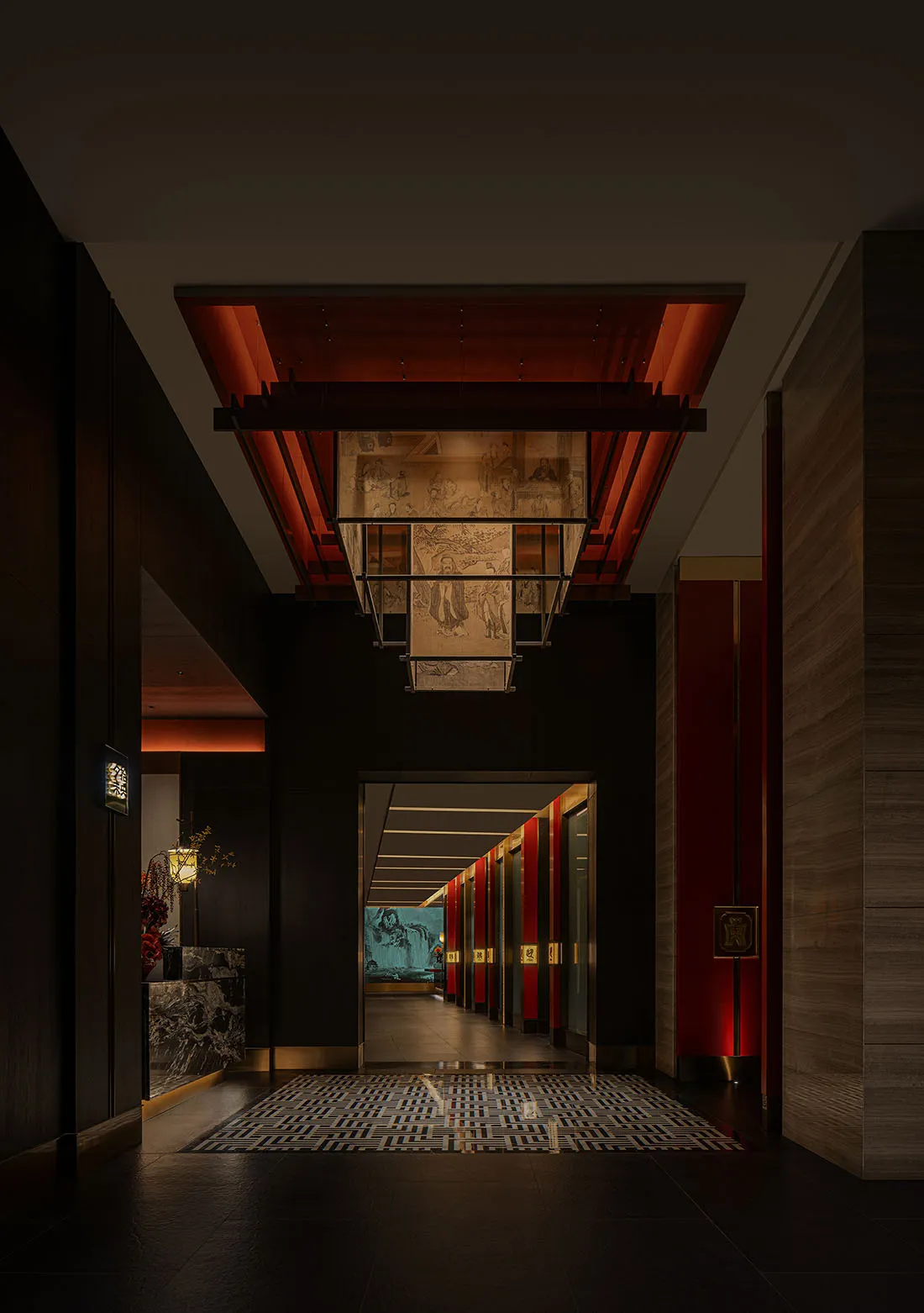 A modern hotel hallway with a black and red color scheme, featuring artwork on the walls and multiple doors leading to different rooms