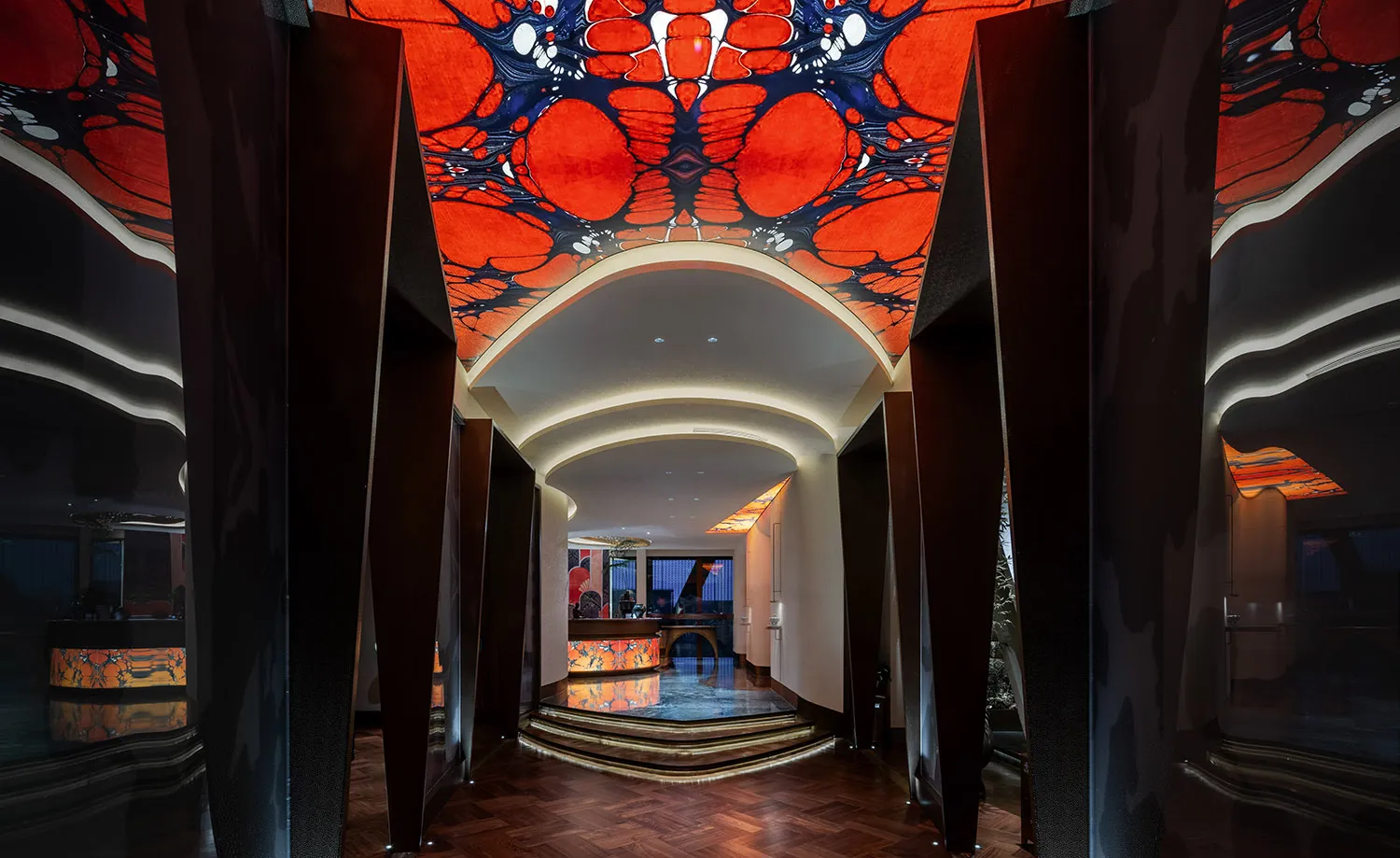 Ornate lobby with a red ceiling design, marble countertop, and a modern luxurious feel