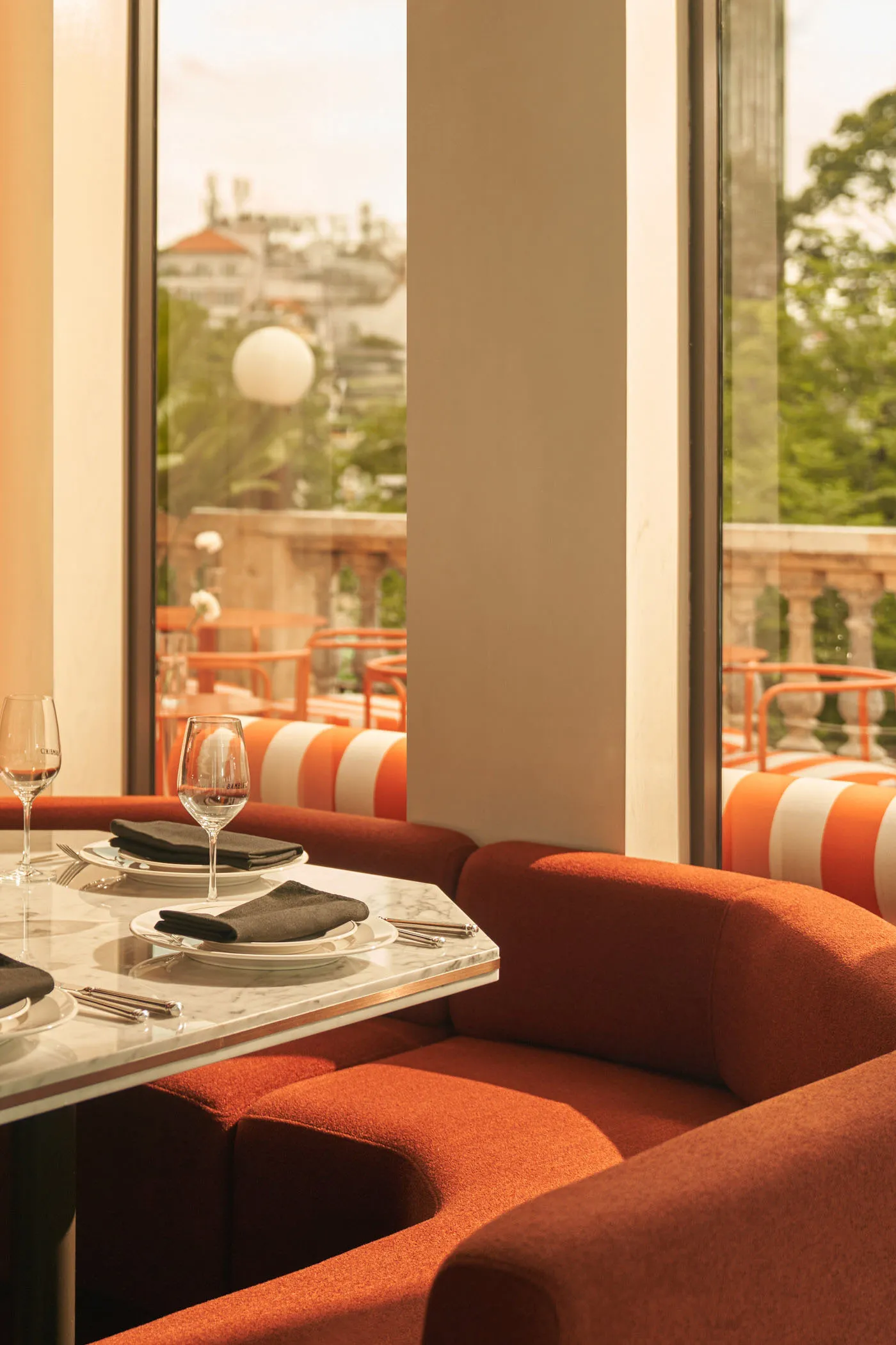Cozy living space with a dining table surrounded by chairs, a couch in the background, and wine glasses and cups on the table