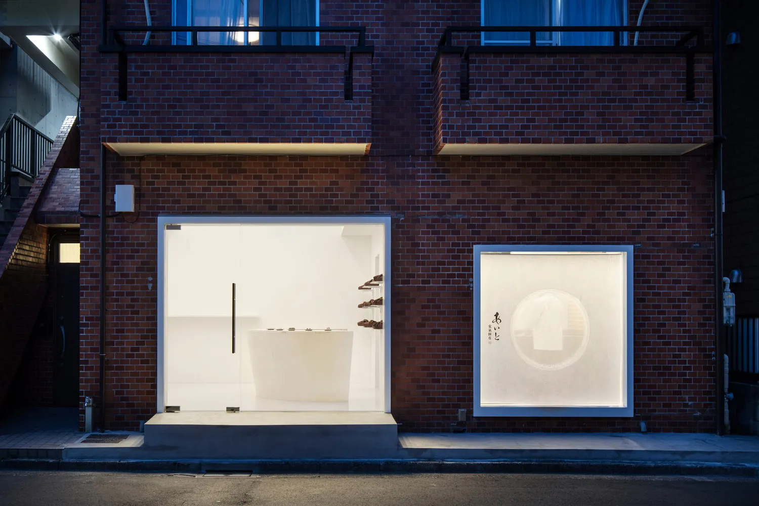 A modern bathroom with a white bathtub visible through an open garage door, well-lit with possible natural or artificial light