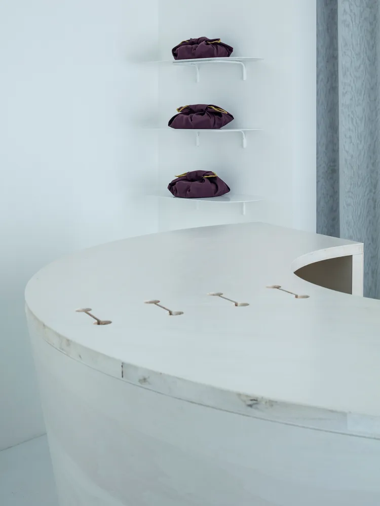 A bathroom with a wooden countertop, three hanging shelves, and various items placed on the countertop, creating an organized and functional space