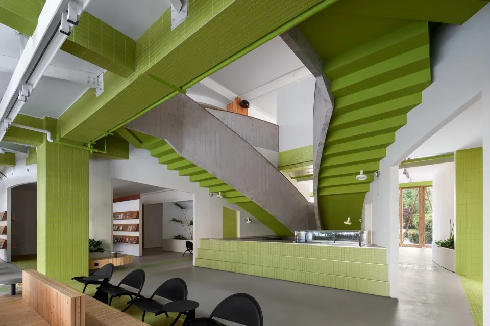 Modern interior space with a green staircase, a countertop, and sleek design elements