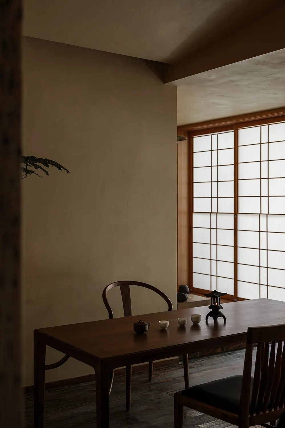 A dining area with a wooden table and chairs, surrounded by natural light from a window, creating a warm and inviting atmosphere