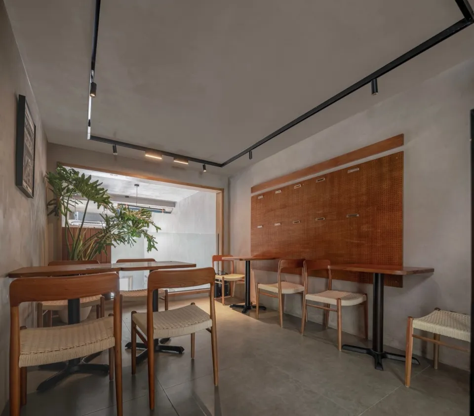 Modern restaurant interior with wooden tables, metal accents, and various seating options