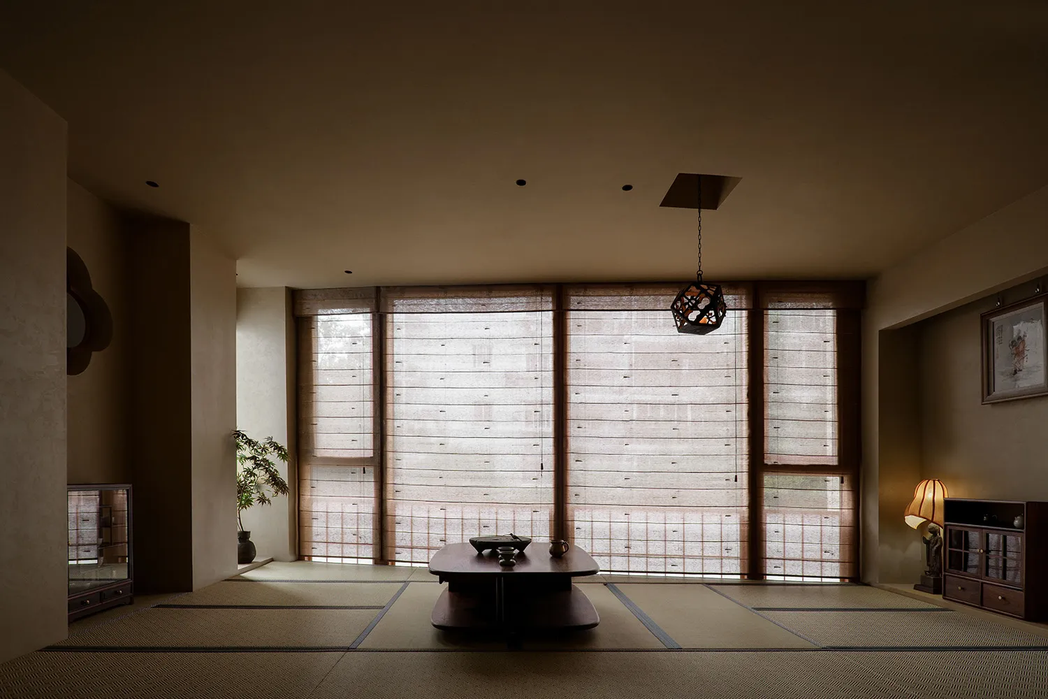 A living area with a wooden floor, two windows, a dining table, and a potted plant, flooded with natural light