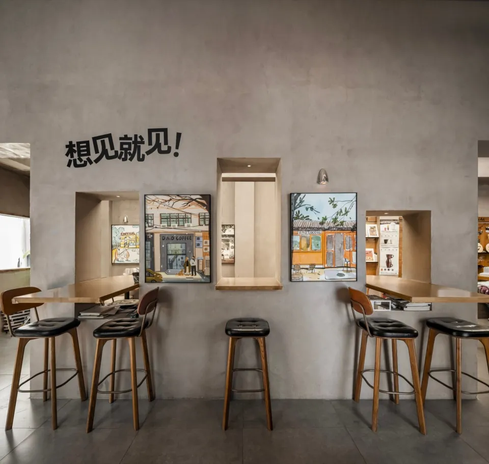 A modern restaurant with gray walls, wooden elements, and a bar area with stools, surrounded by dining tables and chairs, with books on the counter