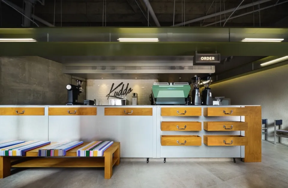 Industrial kitchen with a counter featuring various appliances, clean and organized with a focus on functionality and efficiency