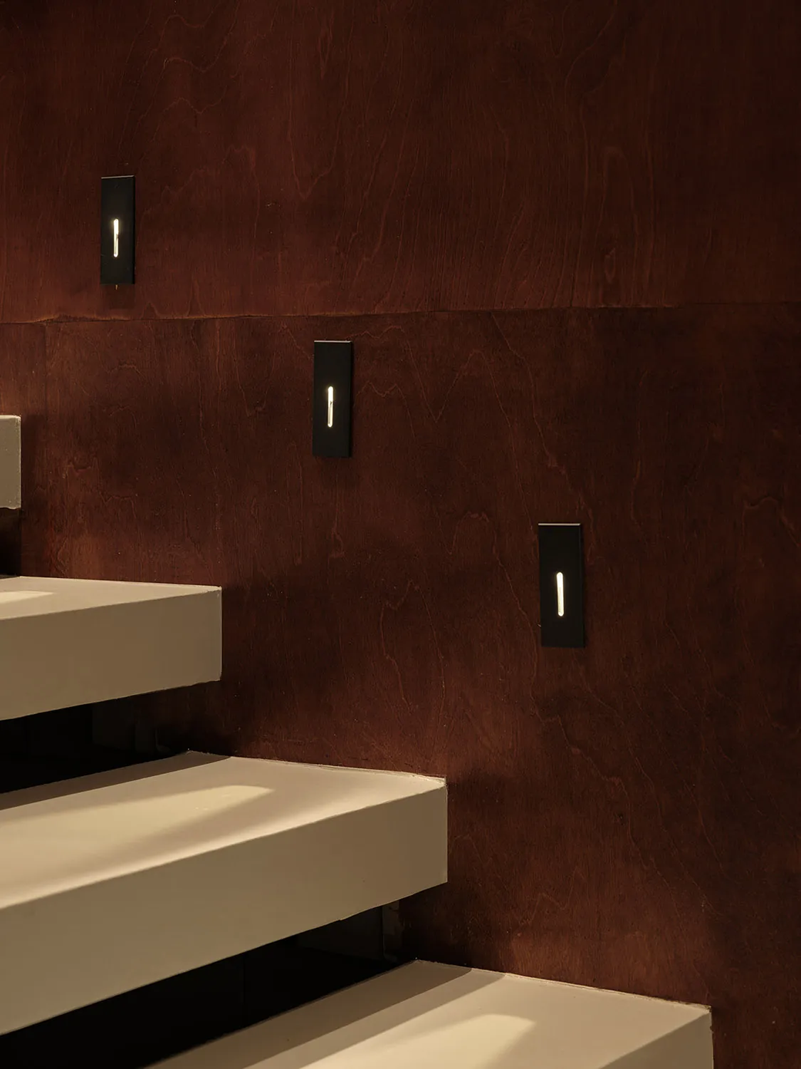 A wooden staircase with brown steps in a well-lit, warm, and inviting interior space