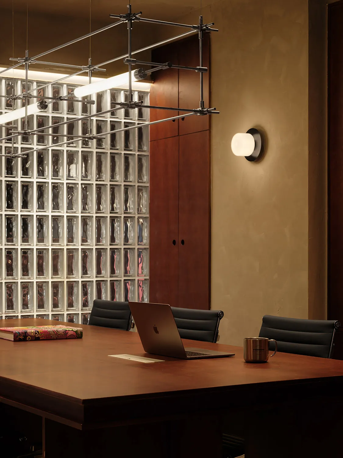 Modern office space with a wooden desk, glass wall, and natural light