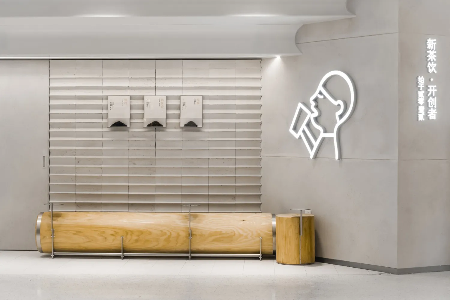 A modern showroom featuring a wooden bench in front of a sign-covered wall with two boxes nearby, exuding a clean and organized atmosphere