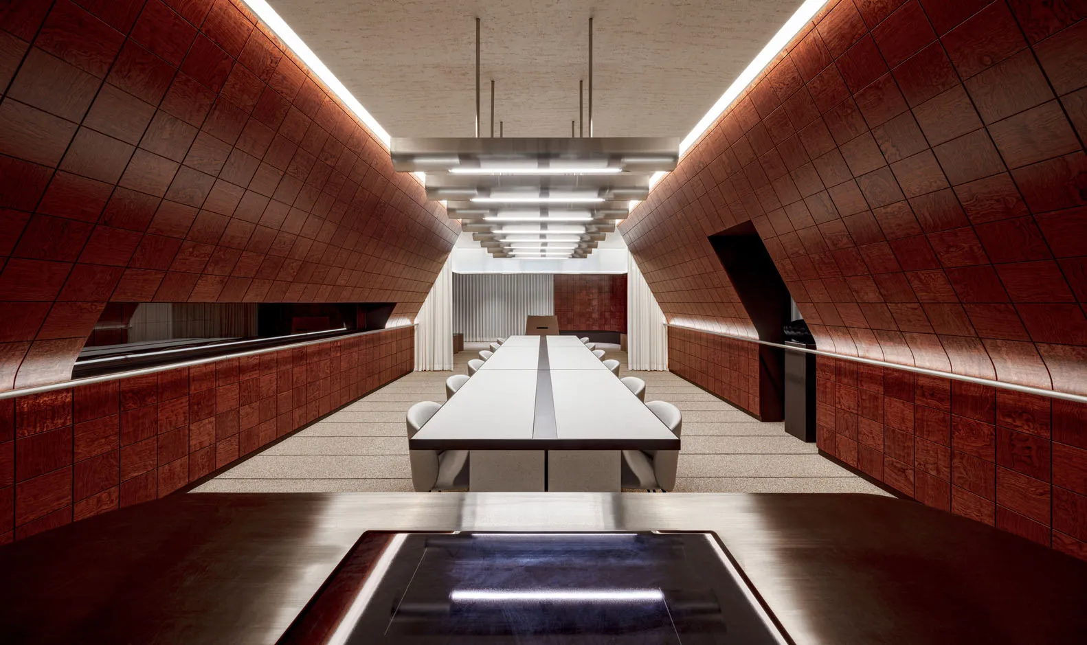 A large dining table surrounded by chairs in a spacious restaurant with wooden floors and walls, creating a warm and inviting atmosphere