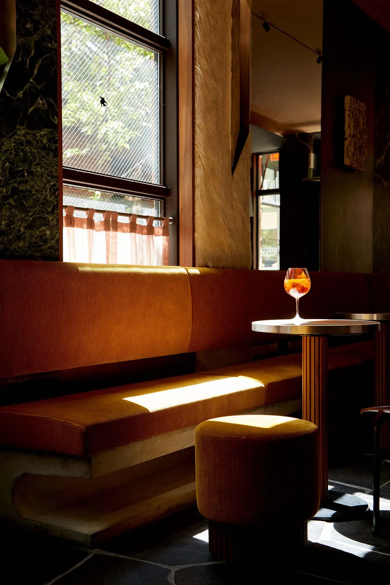 溫馨餐廳內部，設有木製長椅、餐桌與酒杯，營造舒適氛圍