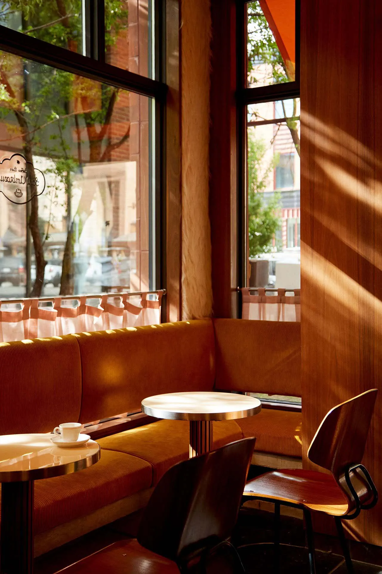 A modern dining area with several tables and chairs, featuring warm wood tones and a cozy atmosphere