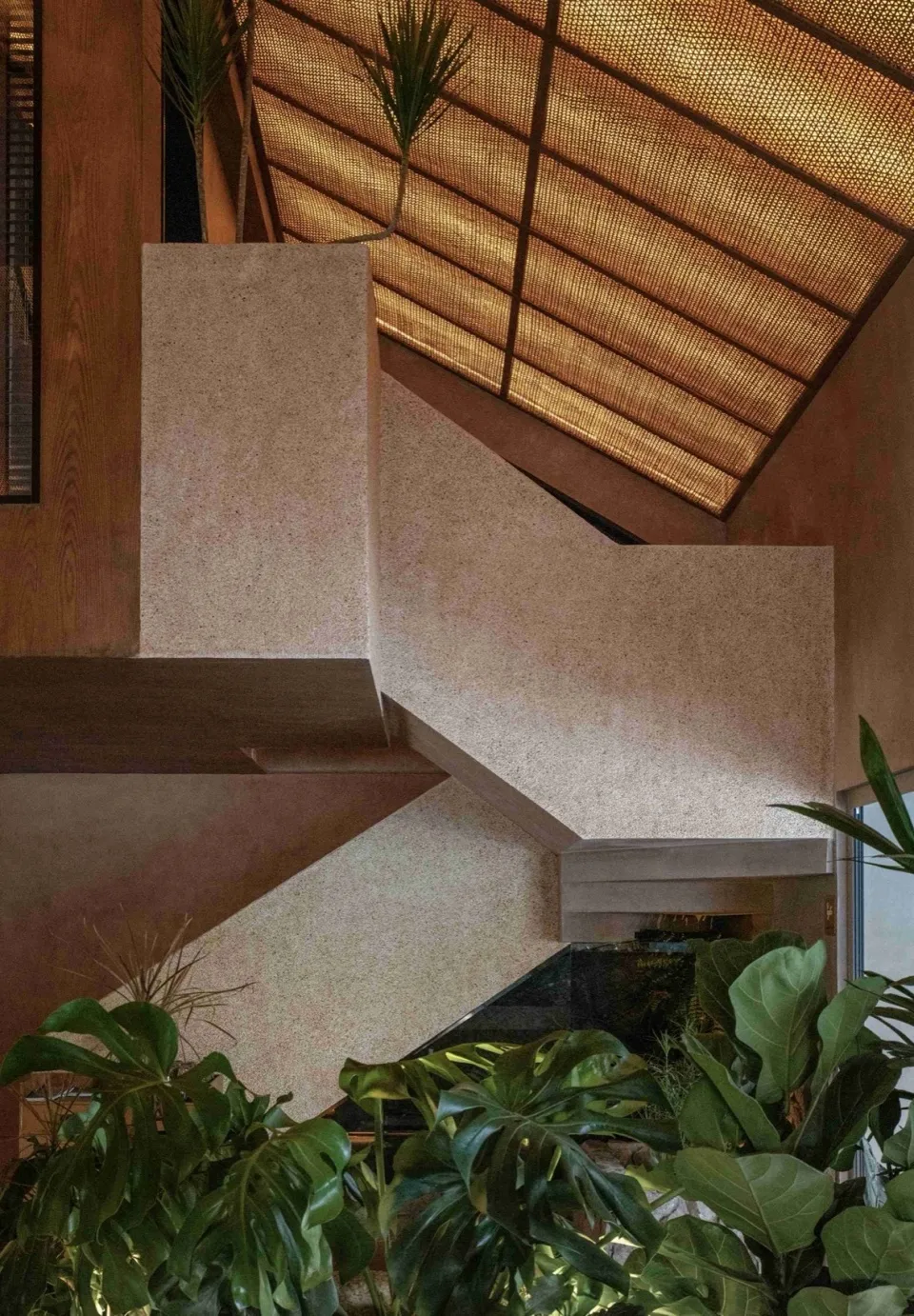 A daytime photo of a simple staircase with concrete steps, set against a neutral background, with natural light illuminating the scene