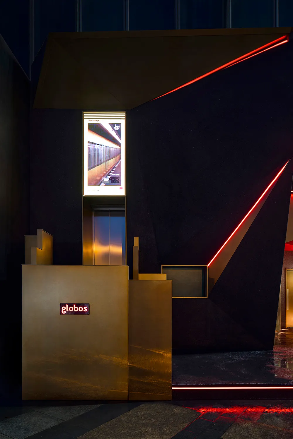 Modern hotel lobby with black and gold decor, two elevators, and a sophisticated atmosphere