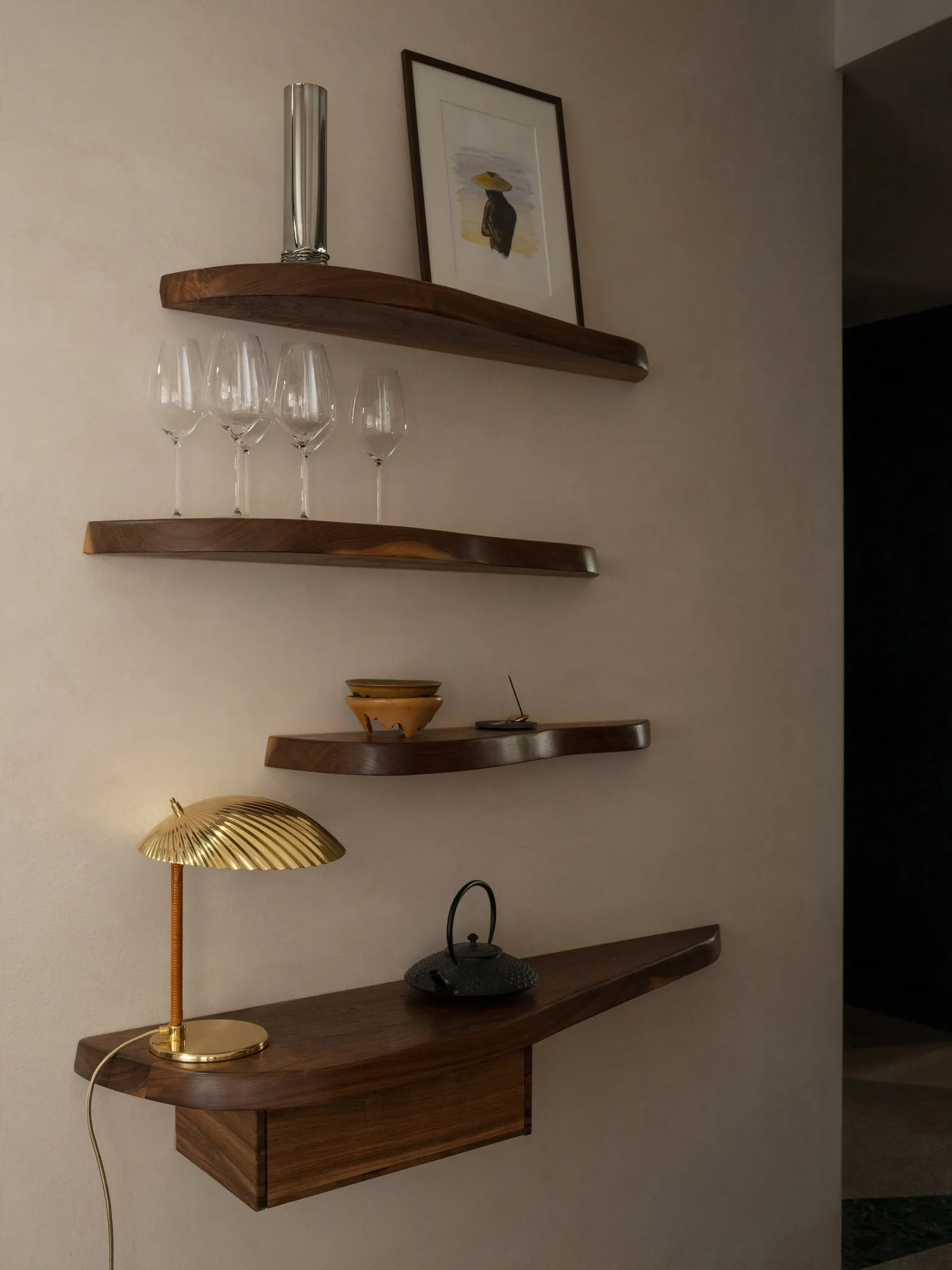 A wooden table in a cozy bar setting with wine glasses, a bowl, and a handbag, suggesting a relaxed social gathering
