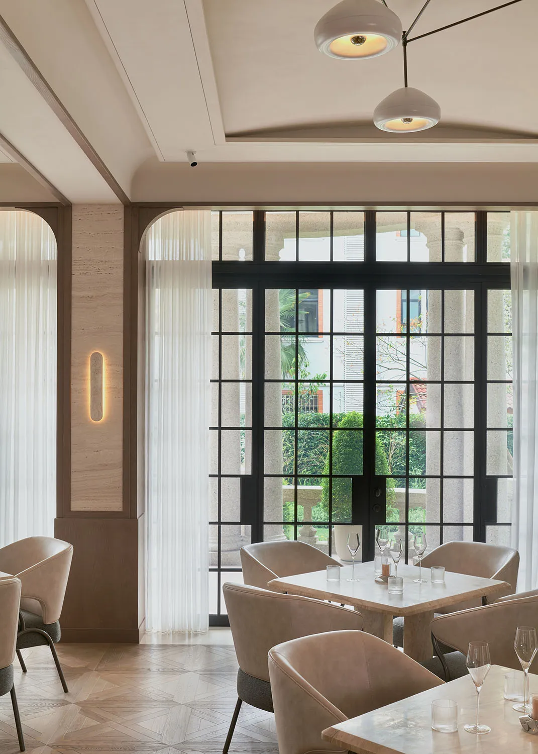 Bright dining space with a large window, modern chairs, a dining table, and a potted plant