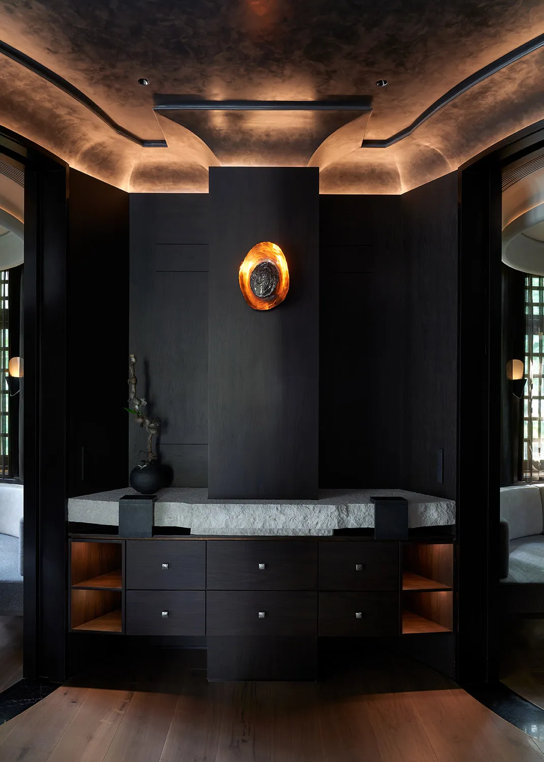 Modern living room with a wooden cabinet, two chairs, and a vase, featuring a sophisticated ambiance