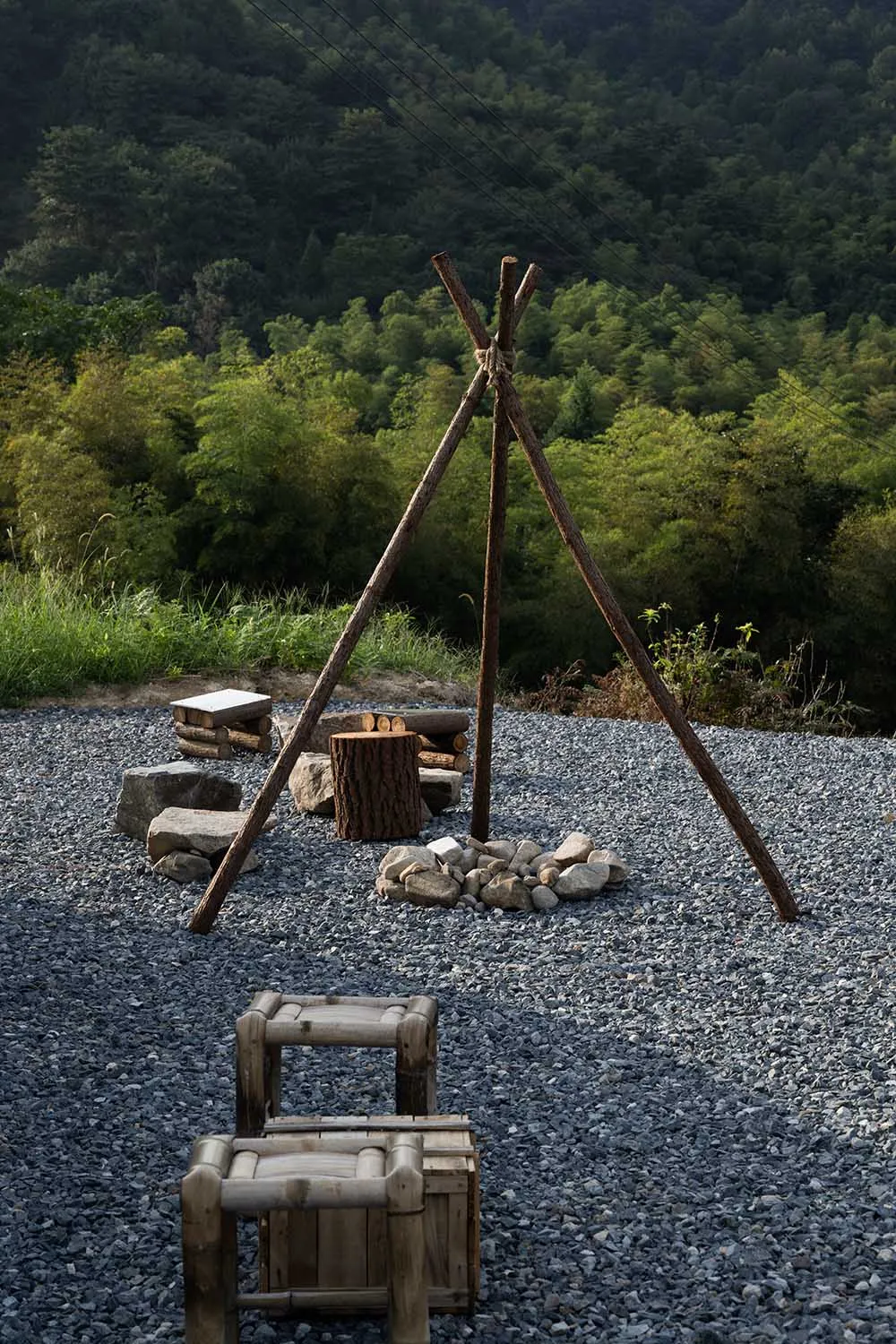 A cozy outdoor camping area with a wooden structure, fire pit, and two benches, perfect for colder months