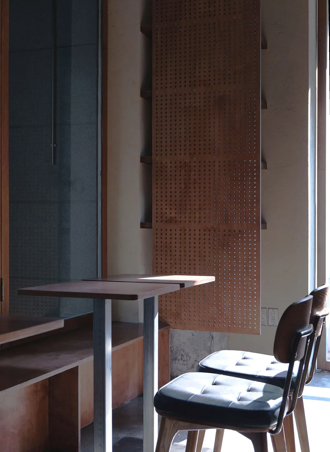 Dining room with a wooden table and leather chairs, surrounded by a warm wooden wall, creating a cozy atmosphere for meals and gatherings
