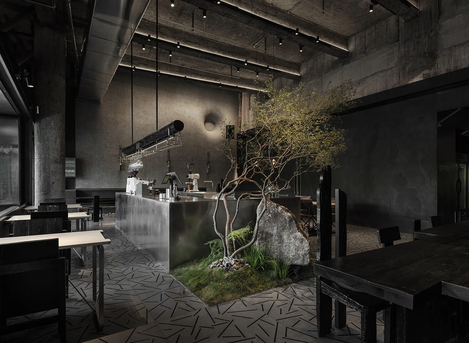 Modern cafe interior with concrete walls, wood elements, and a large potted plant, featuring several dining tables and chairs, and decorative vases