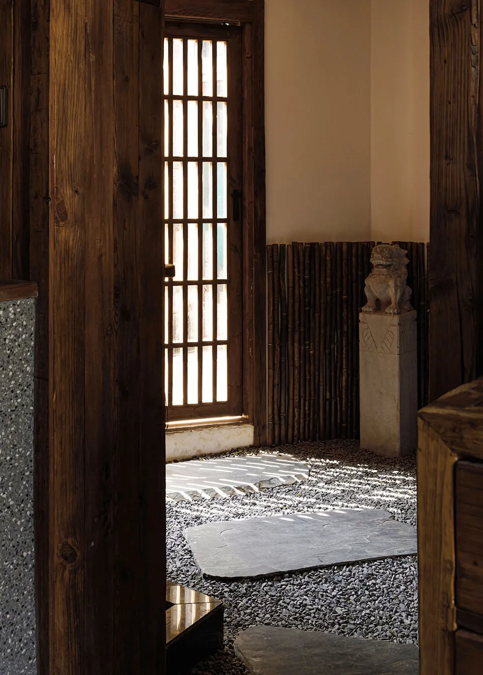 Cozy Asian-style living area with wooden walls and floors, a rug, and a door with a window above it