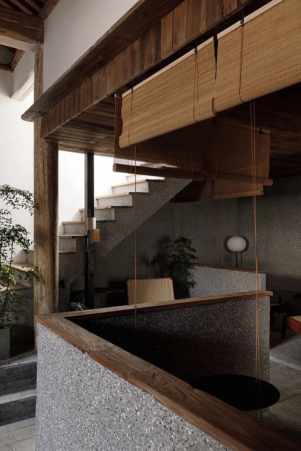 Cozy home interior with a staircase, two chairs, a potted plant, and a vase, featuring a warm and inviting atmosphere