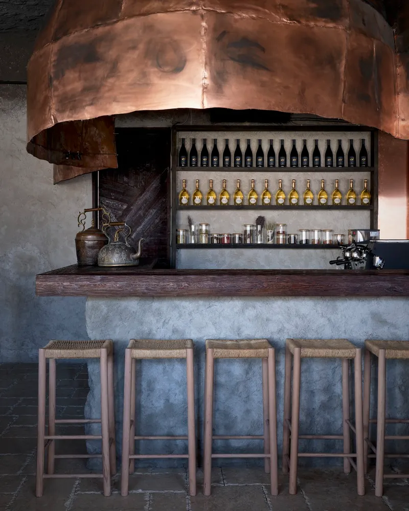 A warm and inviting bar area with a wooden countertop, copper ceiling, and comfortable seating for patrons