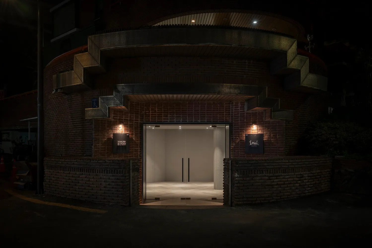 Spacious entrance with brick walls, modern doors, and an inviting archway leading to a warm and rustic interior