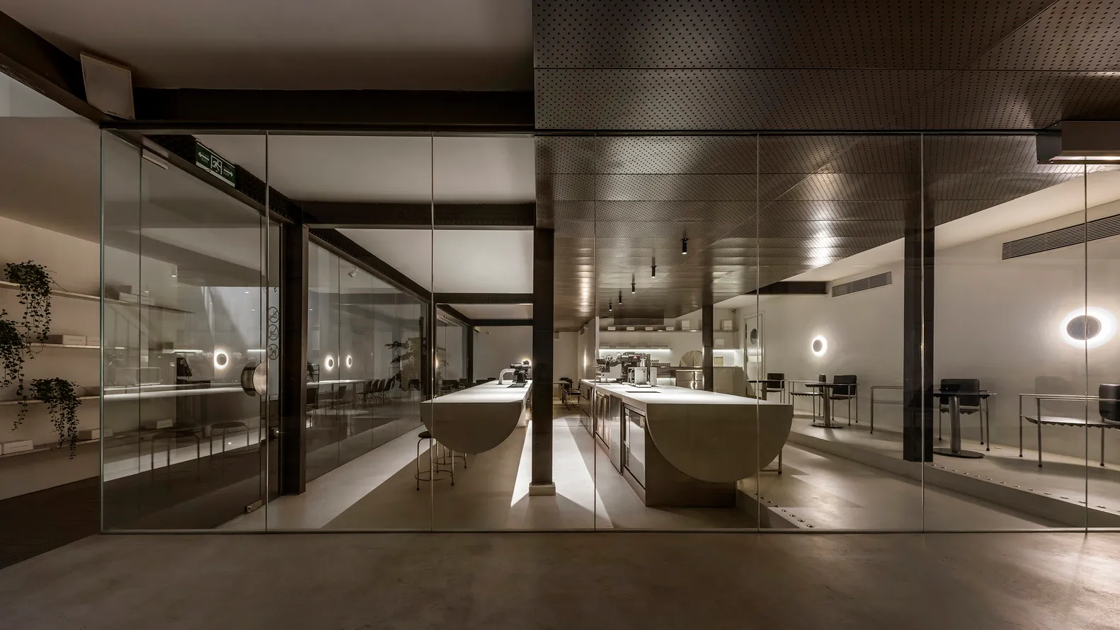Industrial kitchen with white countertops, multiple dining tables, and various appliances, set in a clean and organized space