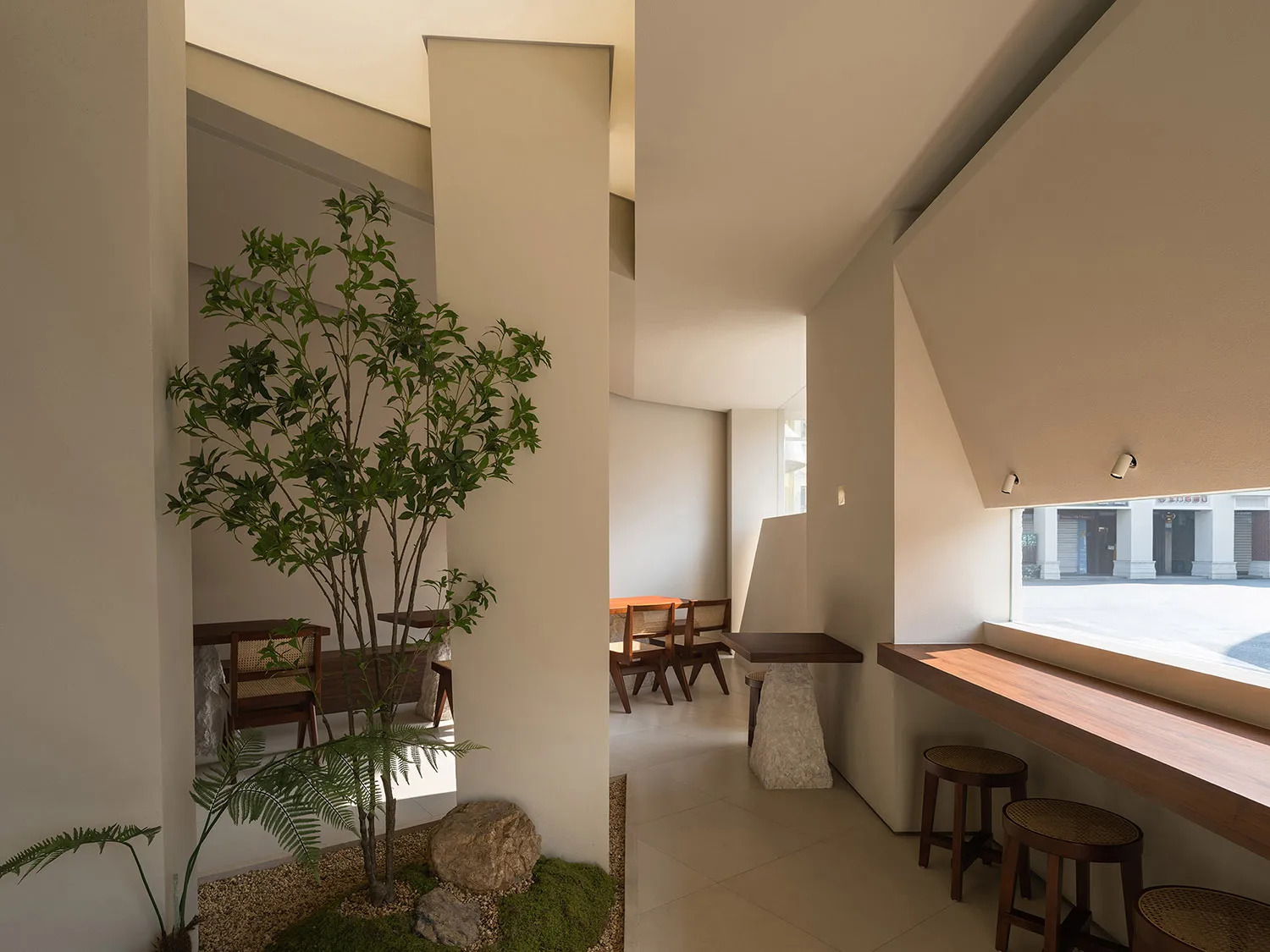 現代餐廳內部，包含用餐區、吧台與盆栽，特色為混凝土牆面與時尚氛圍