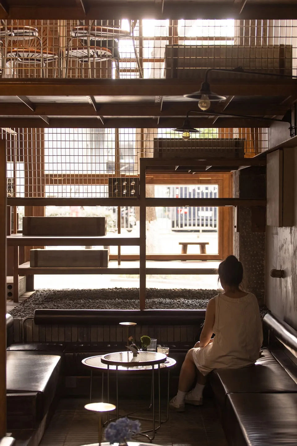 Warm and inviting cafe with wooden walls, hardwood flooring, and natural light from a window