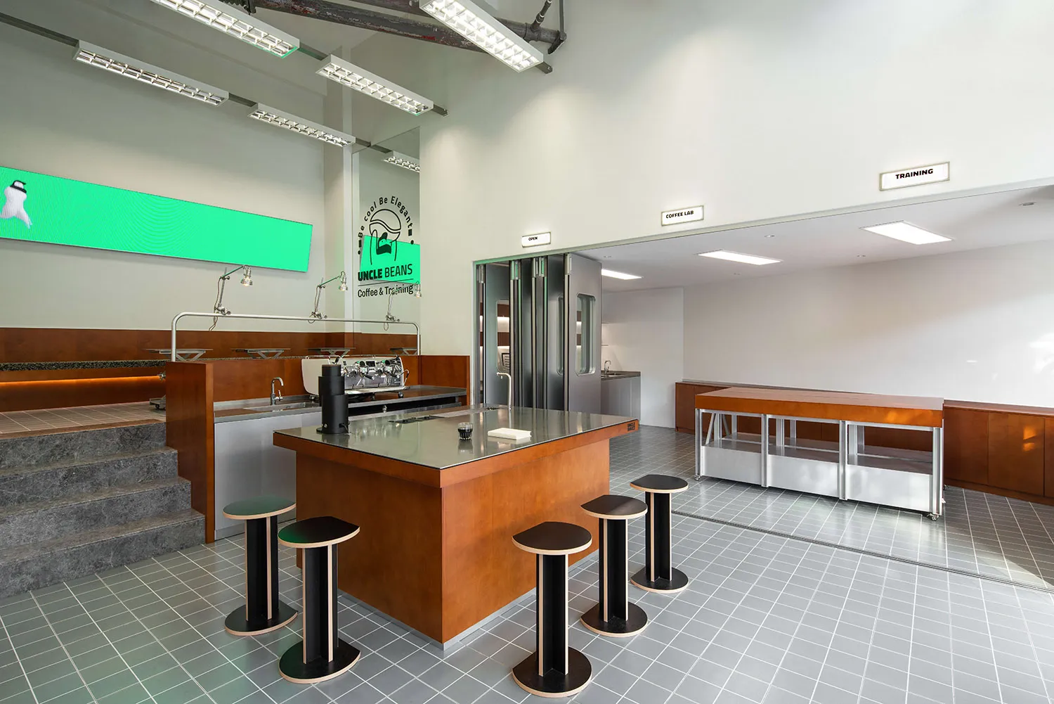 Industrial kitchen with a countertop, appliances, stools, and a clean, well-organized atmosphere