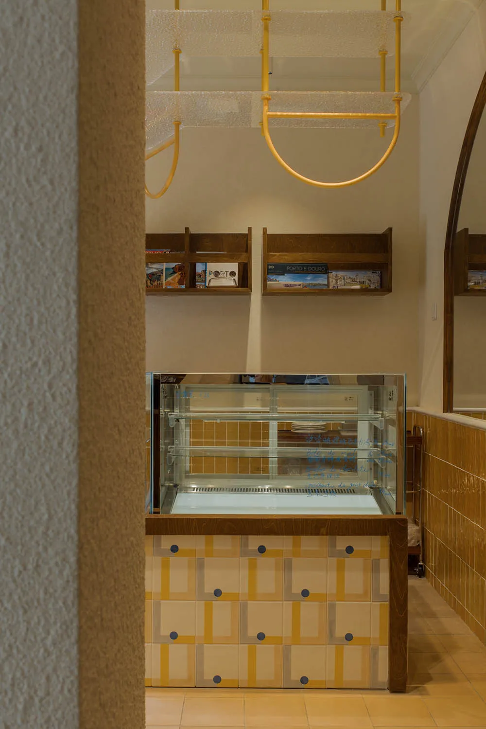 溫馨餐廳內部設有玻璃展示櫃，內陳列各種美食，旁有書籍營造舒適氛圍