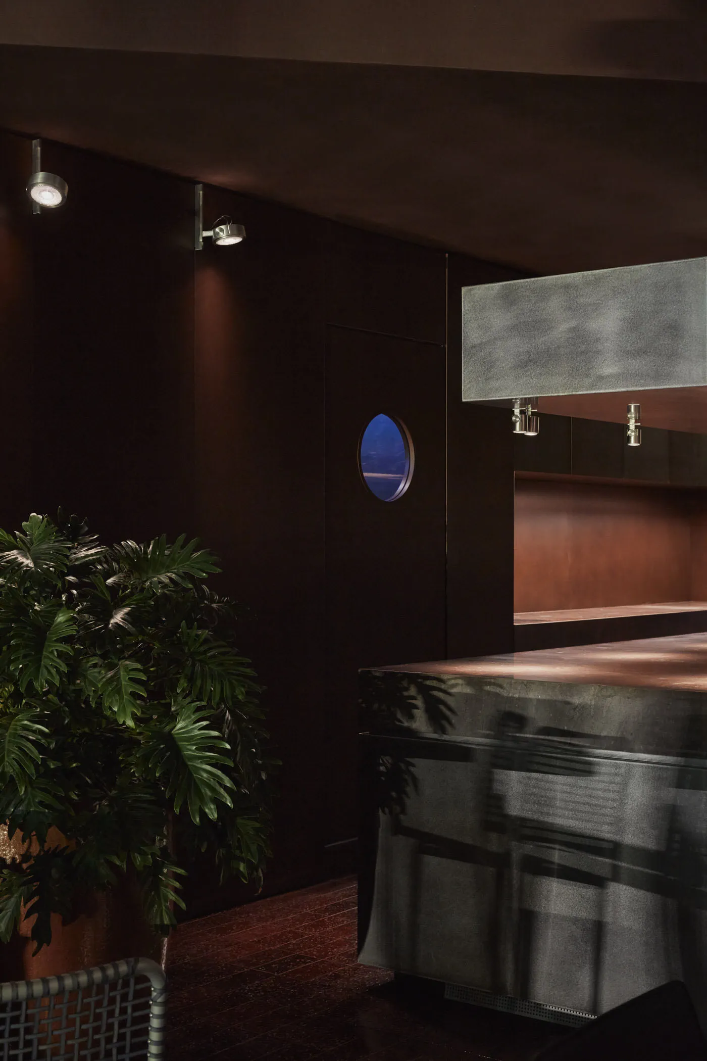 A modern kitchen with a wooden island and marble countertop, featuring two chairs and a warm atmosphere