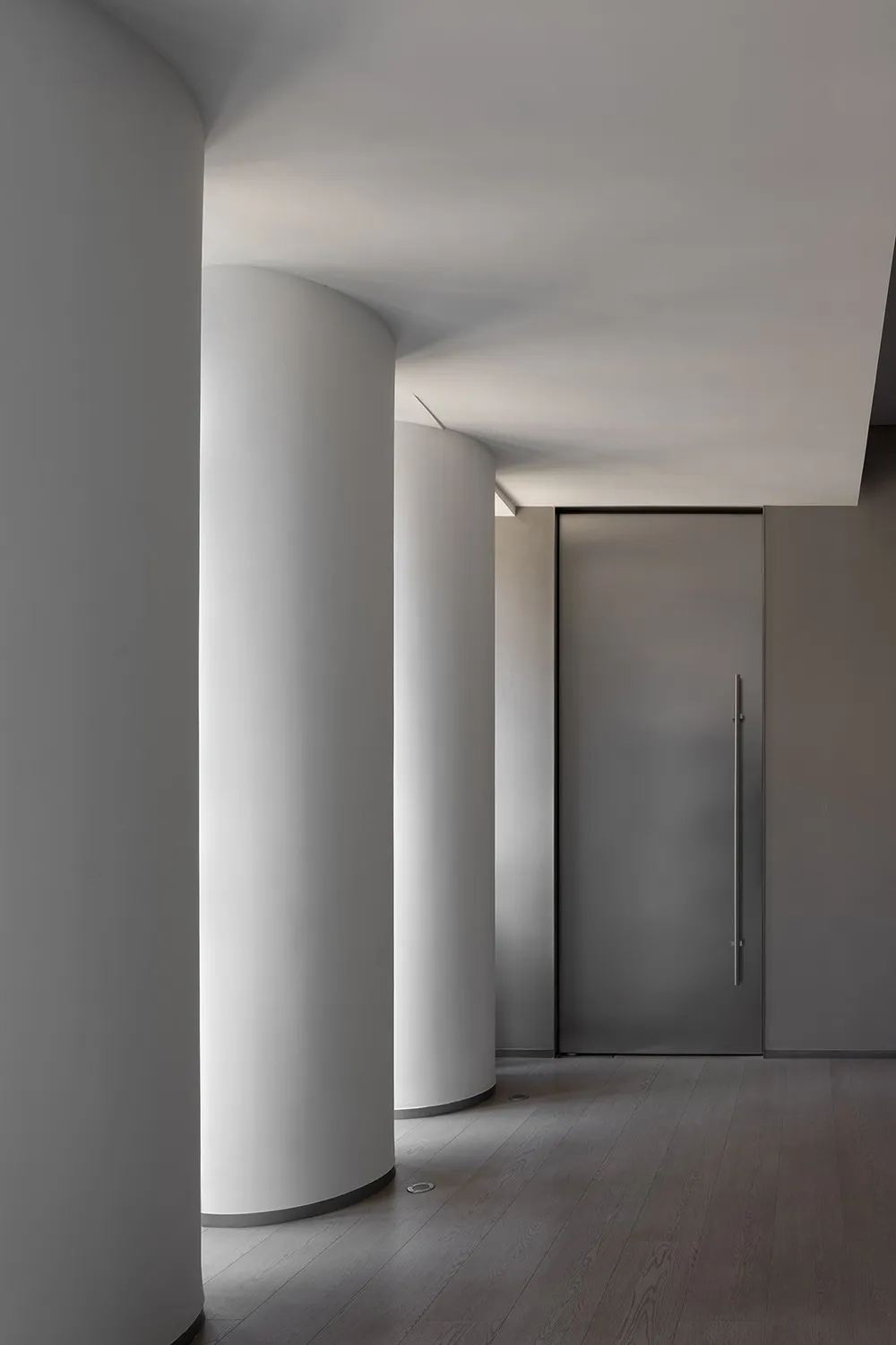 Empty industrial hallway with concrete walls and white pillars, creating a sense of simplicity and modernity