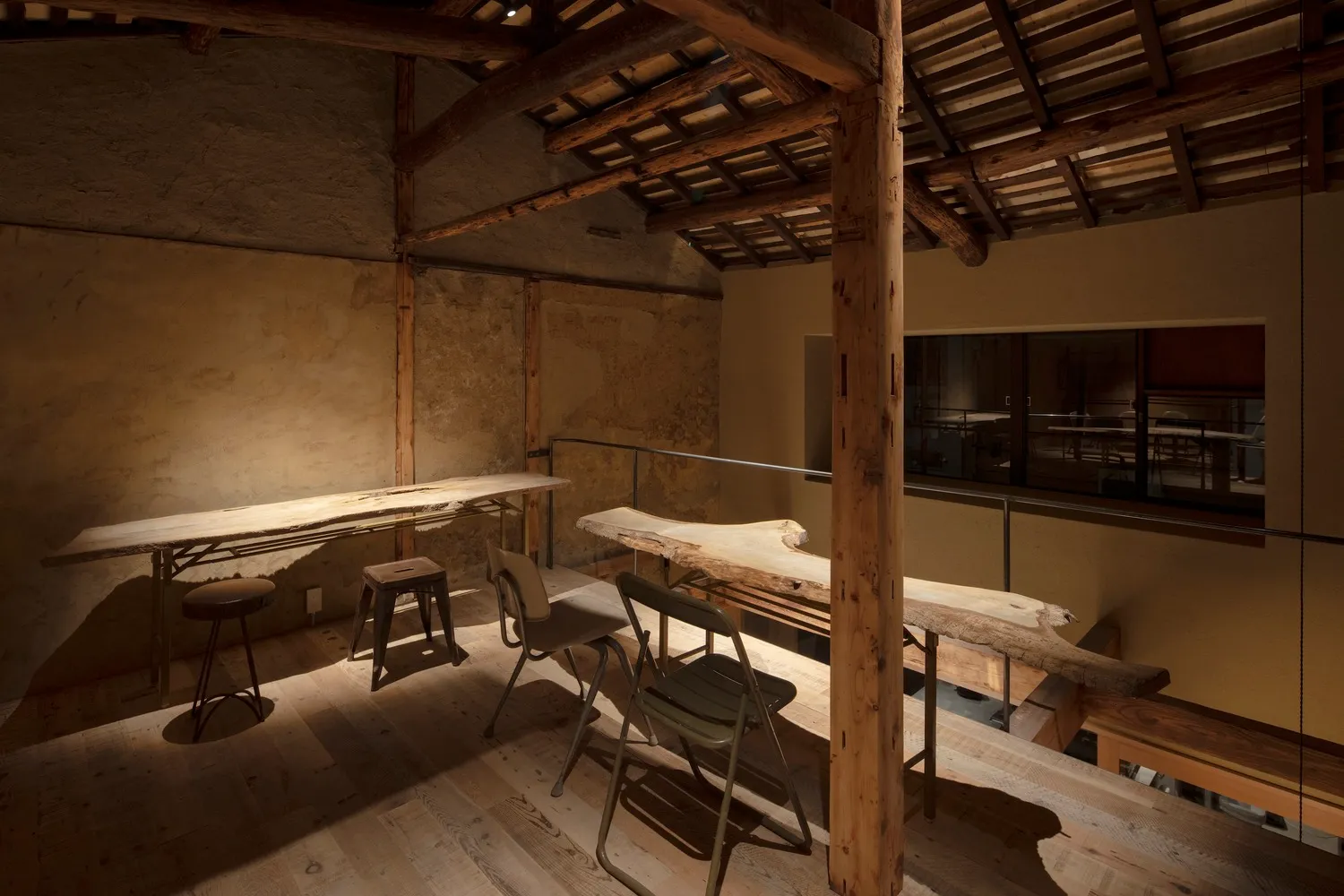 Cozy dining space with a wooden beam, stone wall, and a dining table surrounded by chairs