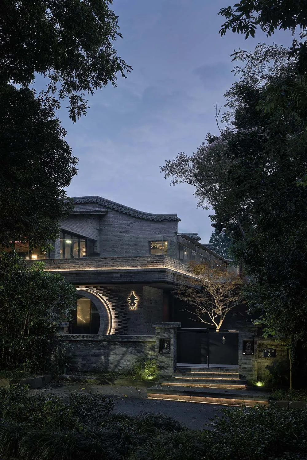 Exterior photo of an Asian-style building with a large stone structure and a courtyard, featuring a blend of traditional and modern elements