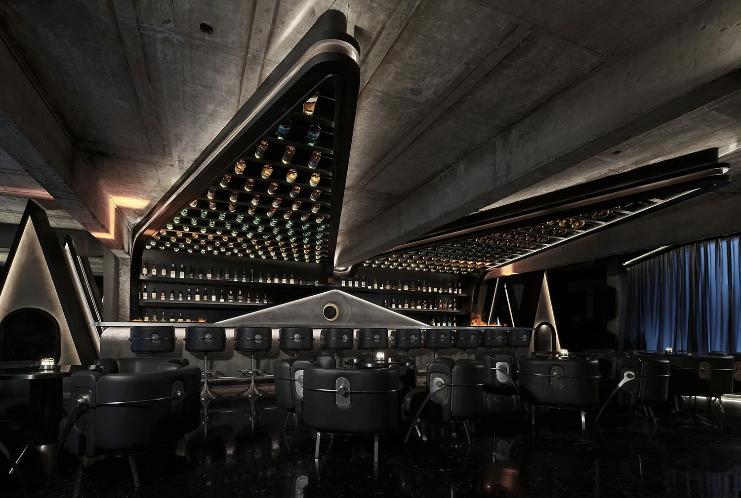 Elegant bar area with wine bottles on display, wooden chairs, and a sophisticated atmosphere