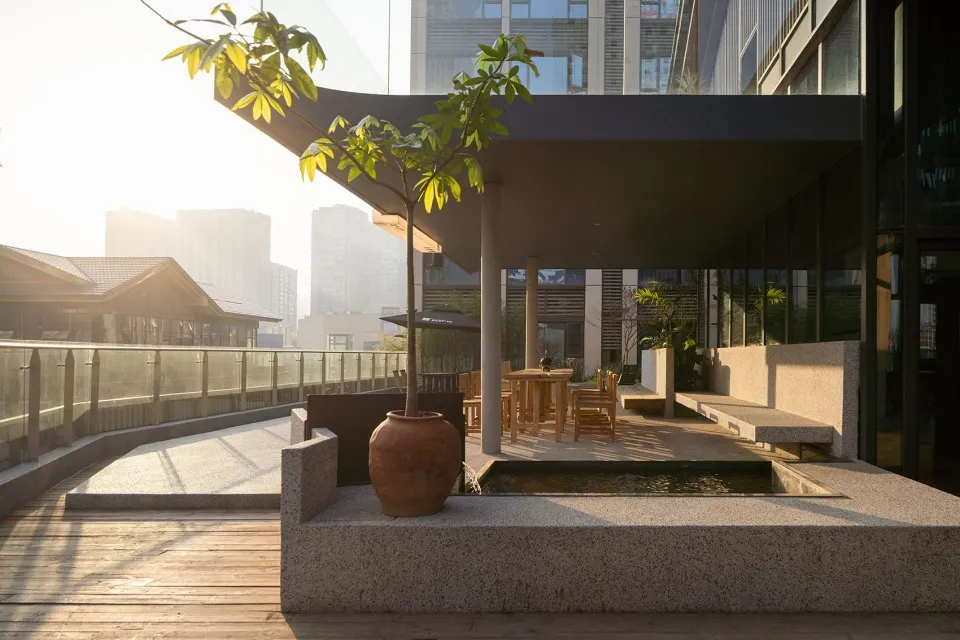 A patio dining area with a table and chairs surrounded by potted plants, creating a relaxing outdoor space for socializing and meals