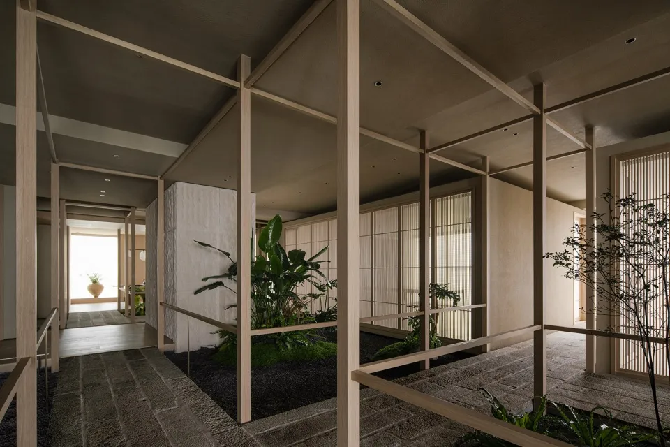 Bright and inviting modern space with white walls, wooden accents, and natural light from windows, featuring potted plants and wooden beams