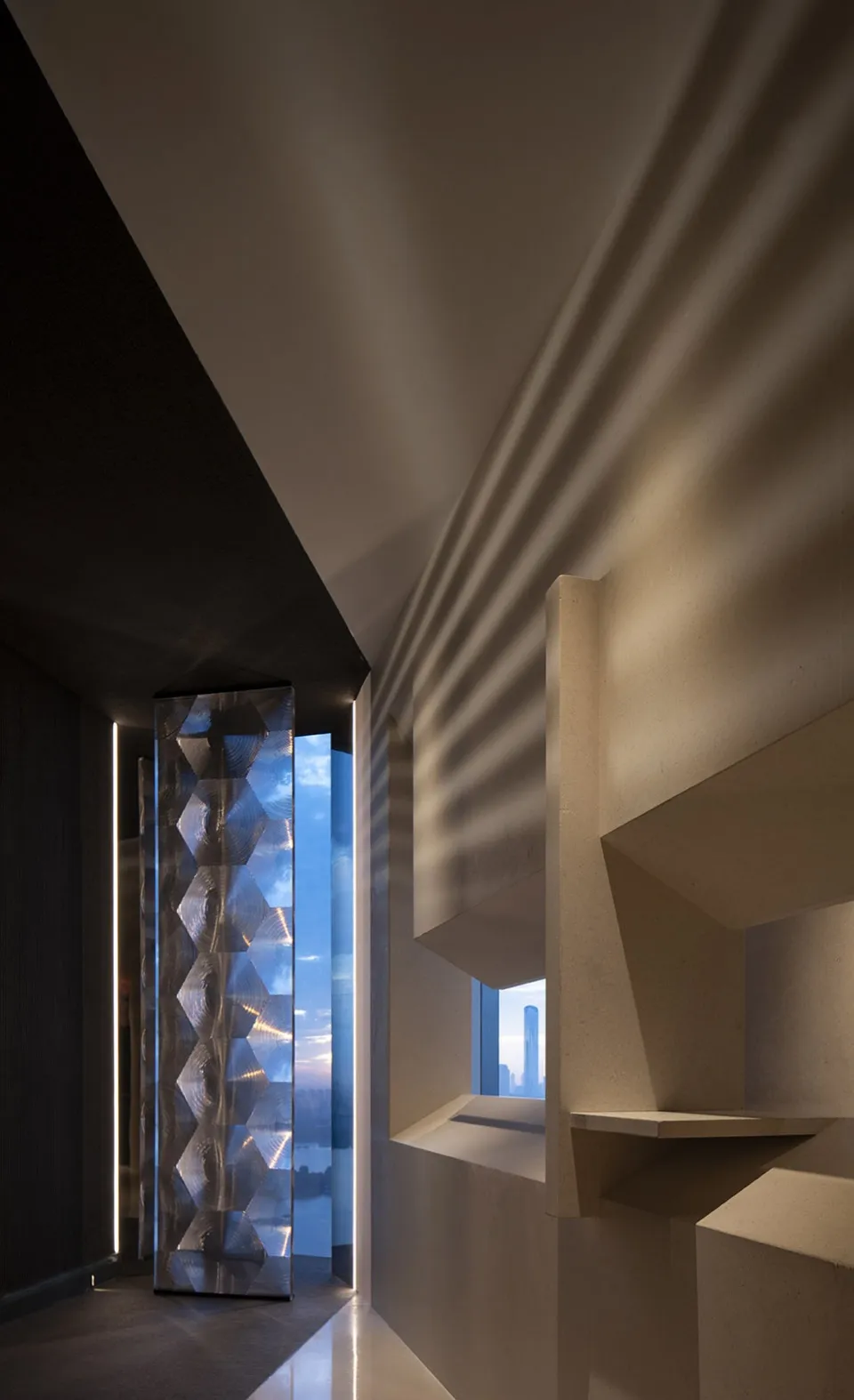 A modern interior space with a staircase, two windows, and concrete walls, well lit by natural sunlight