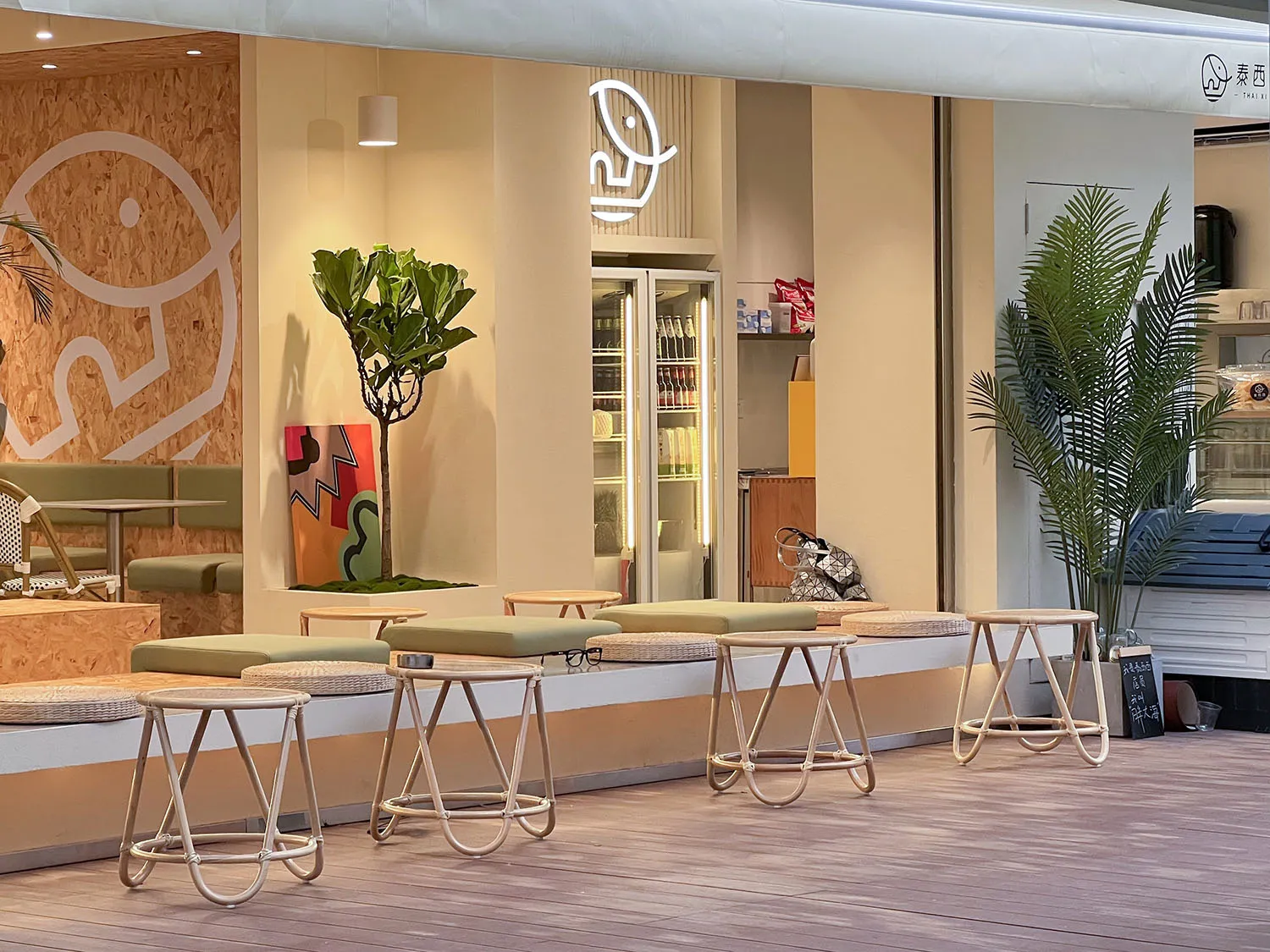 A welcoming cafe space with cushioned chairs, dining tables, and scattered bottles, conveying a cozy atmosphere for customers to gather and enjoy their time together