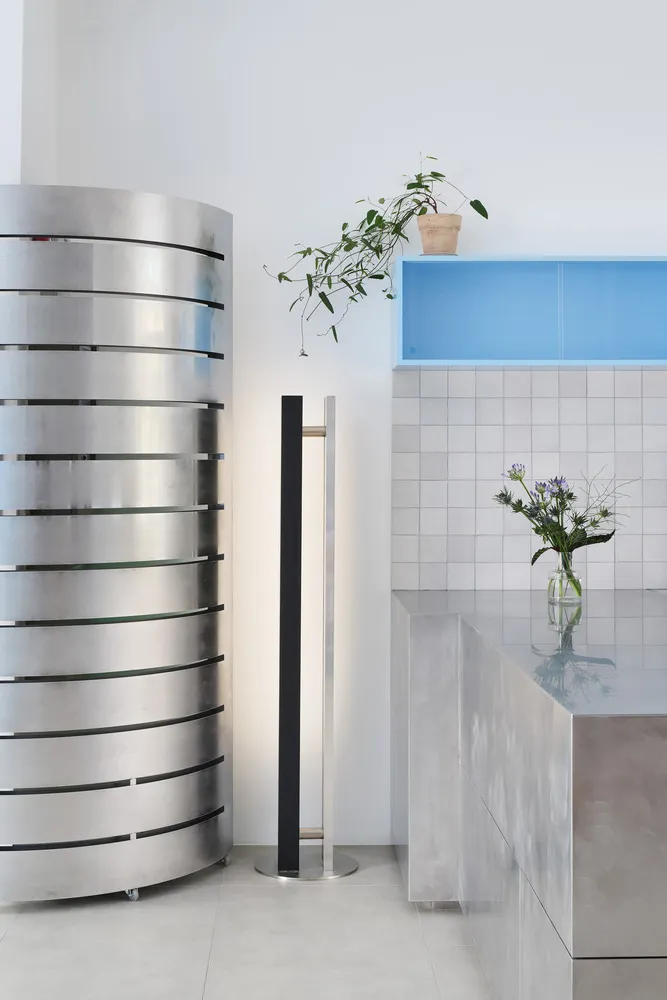 A clean and organized kitchen space with a countertop, potted plant, vases, and a bottle, emphasizing functionality and aesthetics