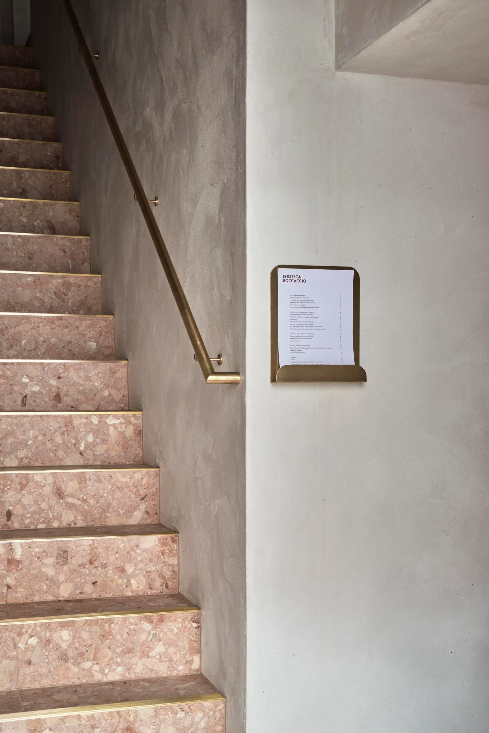 A luxurious staircase with marble steps, a landing, and artwork on the wall, set in an elegant interior design
