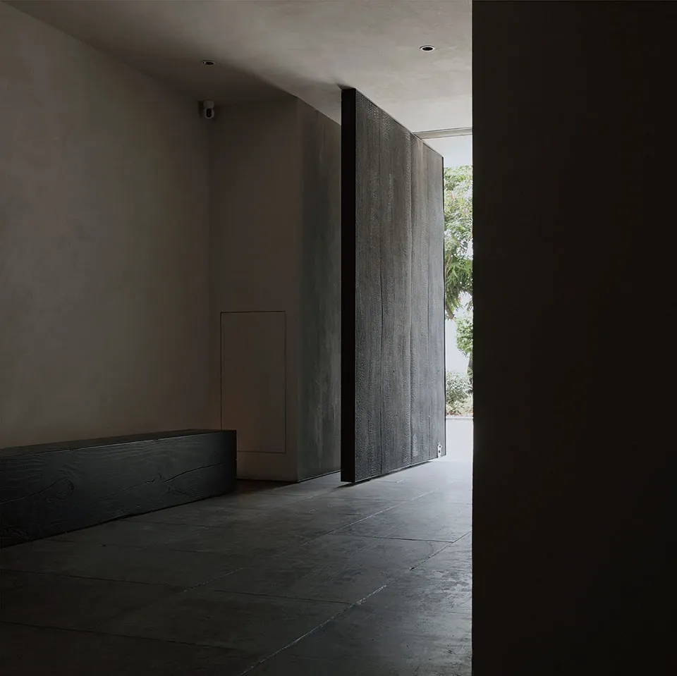 Dimly lit hallway with concrete floor, two doors on either side, and a quiet atmosphere