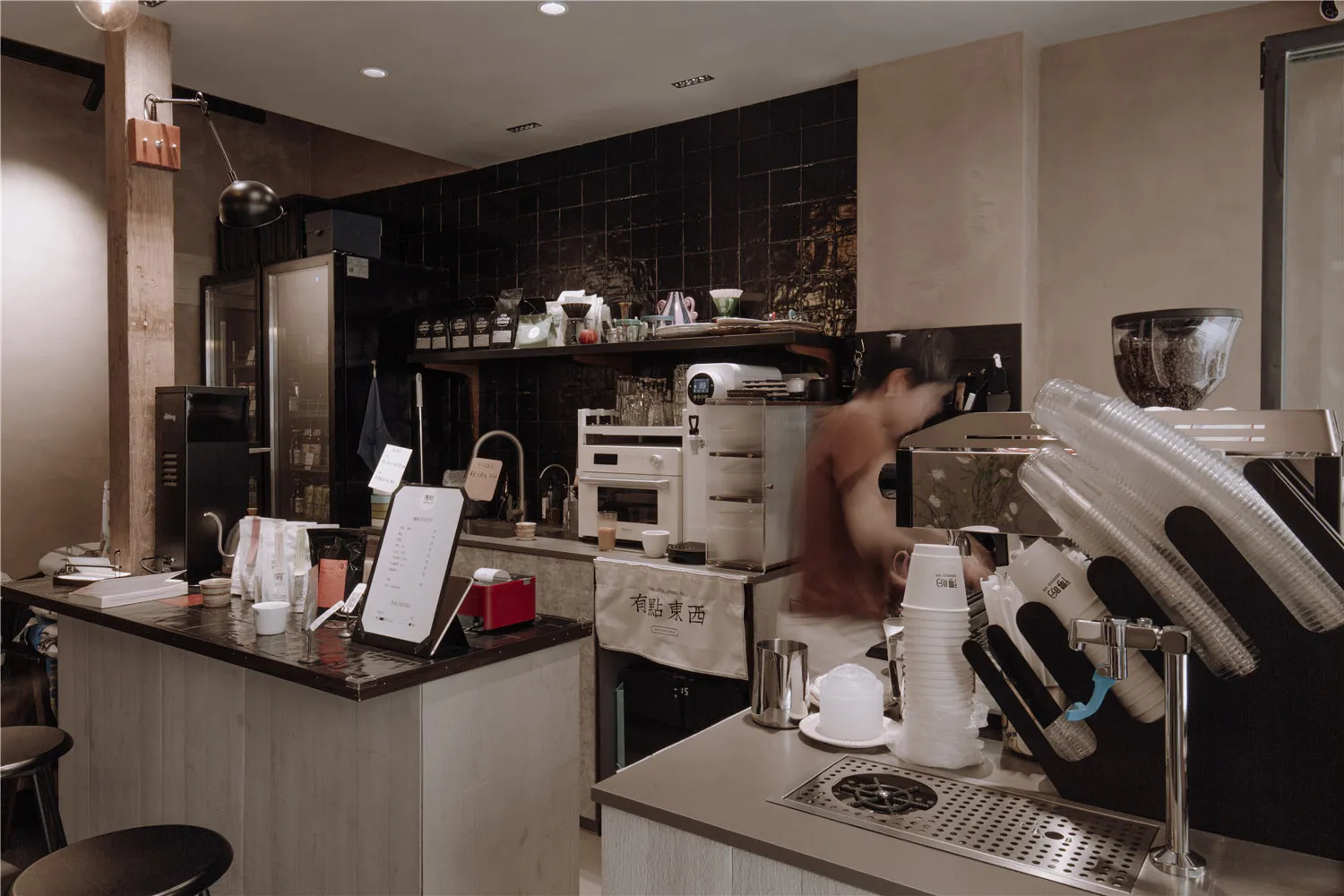 A casual coffee shop interior with cups, bottles, and cakes on display, creating a welcoming atmosphere