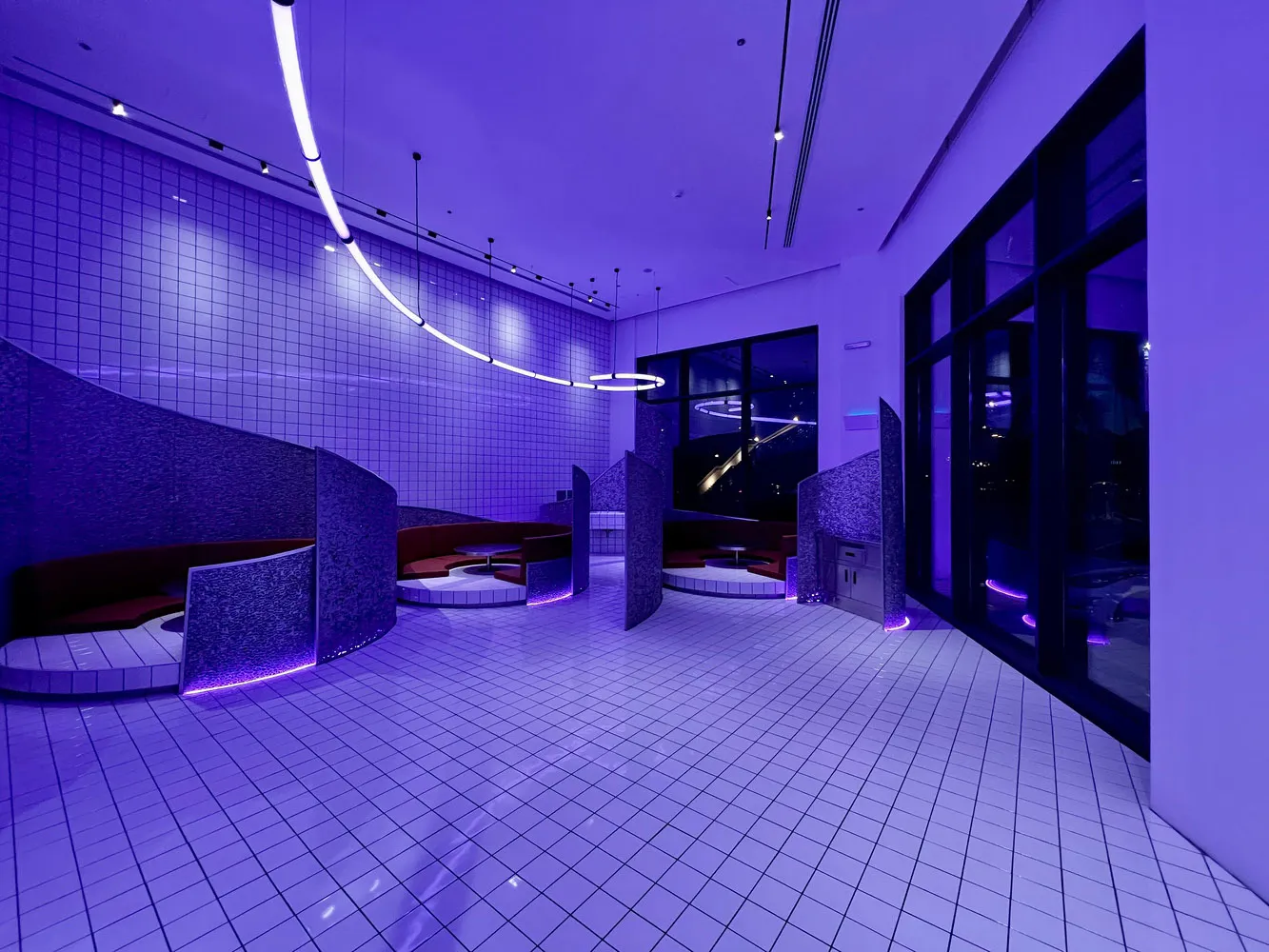 A modern lobby with purple walls and flooring, featuring several chairs and an inviting atmosphere