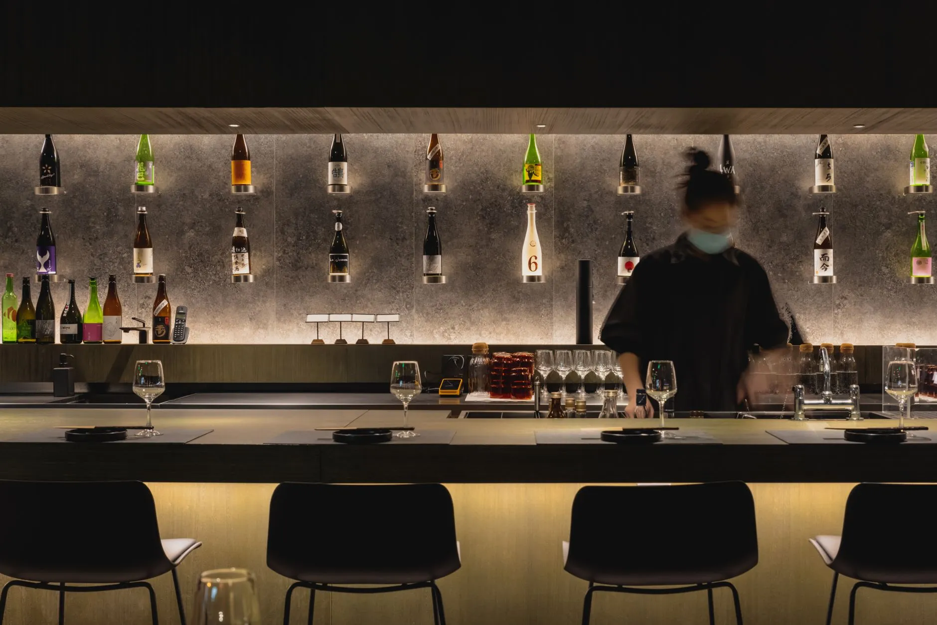 Cozy bar area with a wine counter, multiple chairs, and a dining table, creating a warm and inviting atmosphere for socializing and relaxation