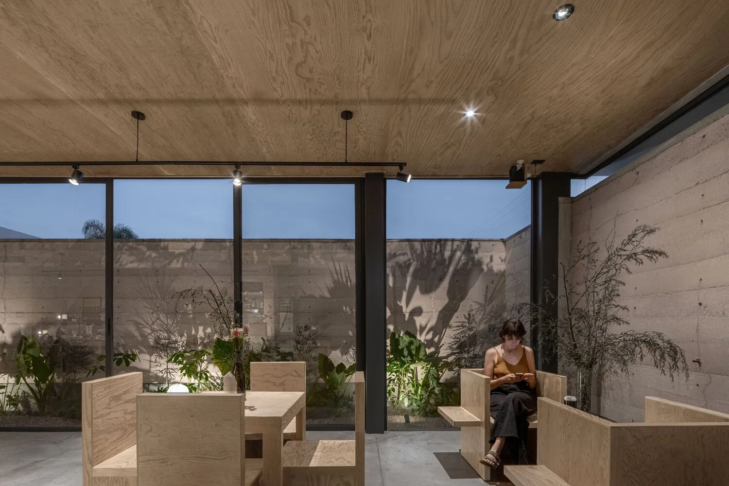 溫馨餐廳空間，配有木質牆面板、盆栽植物與舒適座位區